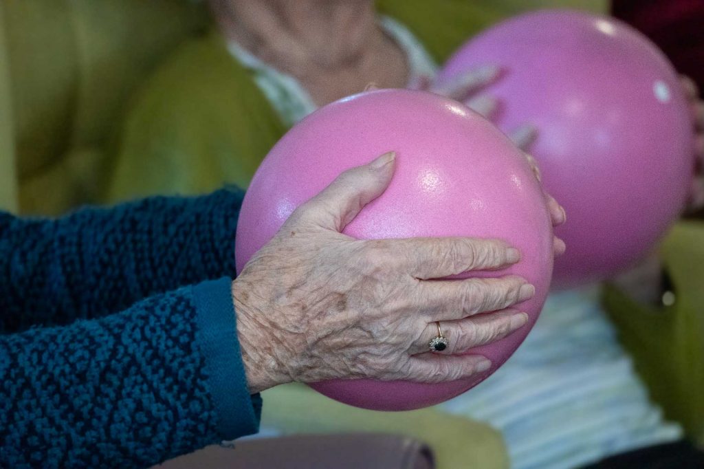 Resident holding a pink exercise ball